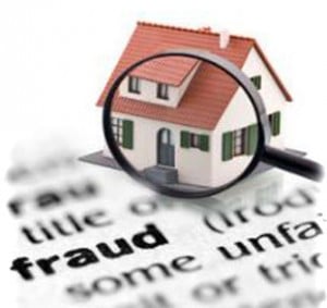 Magnifying glass looking at house on paper saying fraud