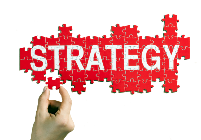 Hand placing final puzzle piece to complete the word “Strategy,” symbolizing building an investment plan.