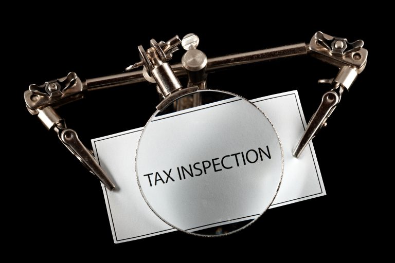 Magnifying glass highlighting tax inspection in relation to HMRC scrutiny of landlord incorporation strategies
