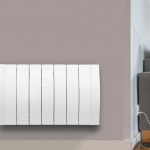 Modern electric radiator mounted on wall beside sofa