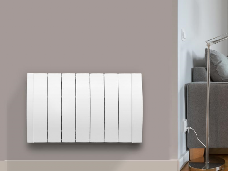 Modern electric radiator mounted on wall beside sofa