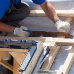 A construction worker fixing a roof