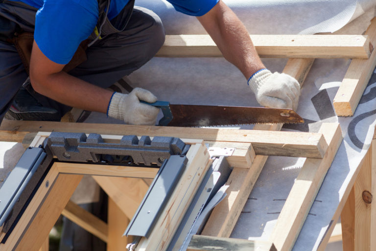 A construction worker fixing a roof
