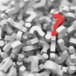 Red question mark standing out among a pile of grey question marks, symbolizing clarity of purpose.