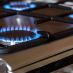 Gas hob burner with blue flame during operation, relating to gas safety checks after appliance repairs