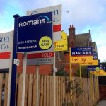 Property for sale and rent signs outside UK homes highlighting active rental market