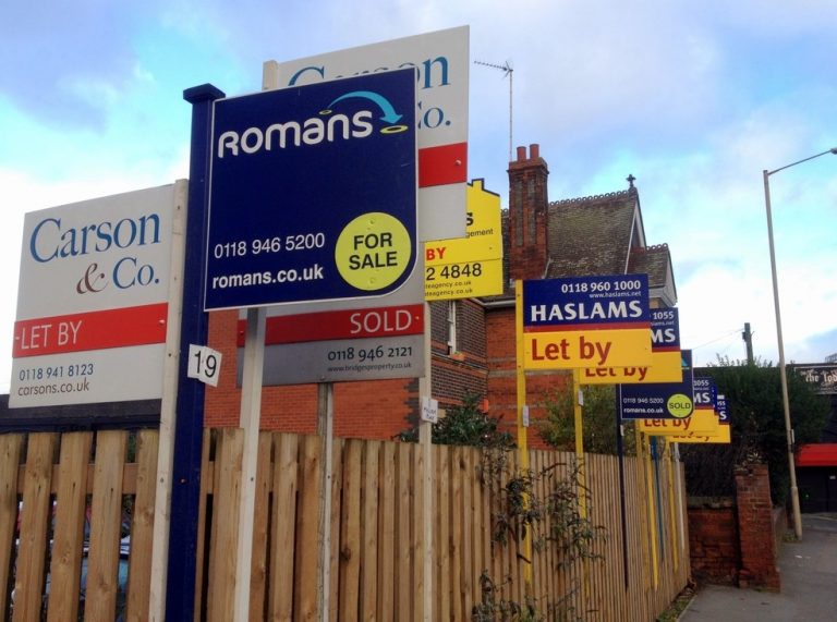Property for sale and rent signs outside UK homes highlighting active rental market
