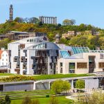 Modern Scottish Parliament building in Edinburgh with Calton Hill in the background