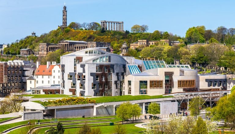 Modern Scottish Parliament building in Edinburgh with Calton Hill in the background