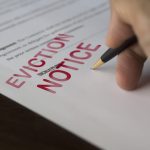 Hand signing an eviction notice related to Section 21 concerns
