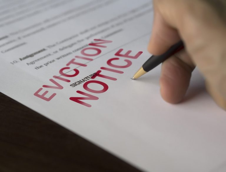 Hand signing an eviction notice related to Section 21 concerns