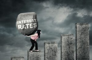 woman carrying rock with rising interest rates property118.com