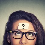 Woman looking up at a question mark sticky note on her forehead, symbolising uncertainty about renting through a Ltd company