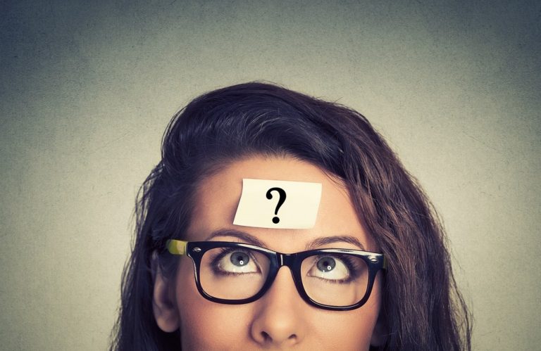 Woman looking up at a question mark sticky note on her forehead, symbolising uncertainty about renting through a Ltd company
