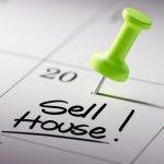 Calendar with green pin marking date and note to sell house.