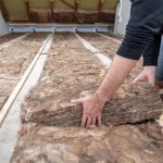 man laying loft insulation property118.com