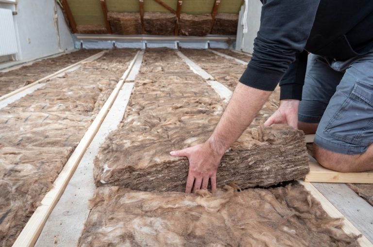 man laying loft insulation property118.com