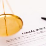 Lease agreement document with scales of justice and pen, symbolizing landlord and tenant legal rights.