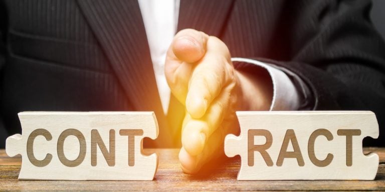 Hand separating wooden puzzle pieces symbolising a broken contract in an eviction context