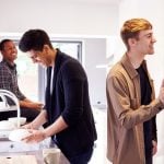 Students sharing kitchen chores in a university house share