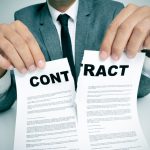Businessperson tearing a contract in half, symbolizing termination of an agreement