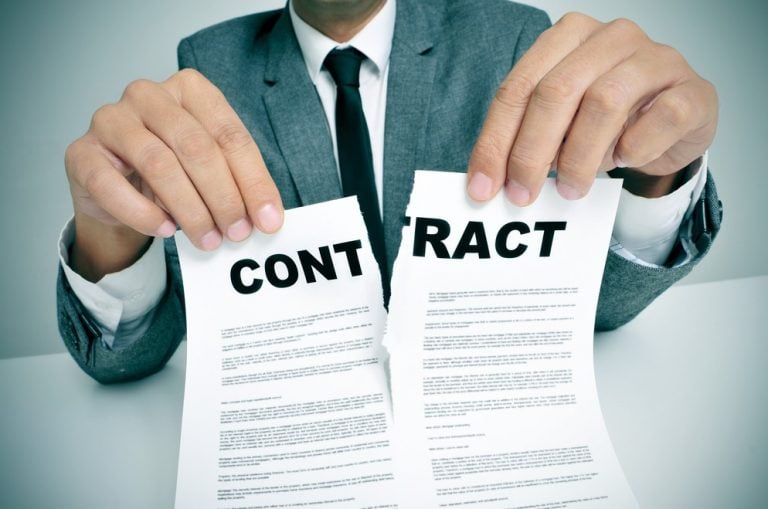 Businessperson tearing a contract in half, symbolizing termination of an agreement