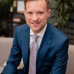 Business professional in blue suit representing NRLA leadership on housing crisis.