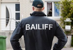 Pic of bailiff outside a tenants house arrears landlords property118