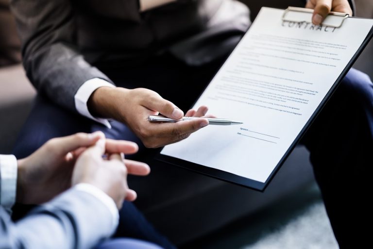 Landlord reviewing a property management contract before signing termination terms.