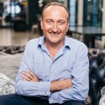 Smiling business professional sitting confidently in a modern office setting