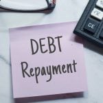 Debt repayment reminder with calculator and pen on desk, symbolizing rent recovery and financial management.