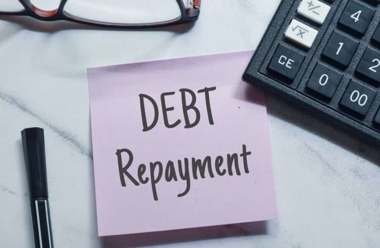 Debt repayment reminder with calculator and pen on desk, symbolizing rent recovery and financial management.