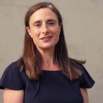 Professional woman standing outdoors, illustrating commentary on pressures facing renters and landlords