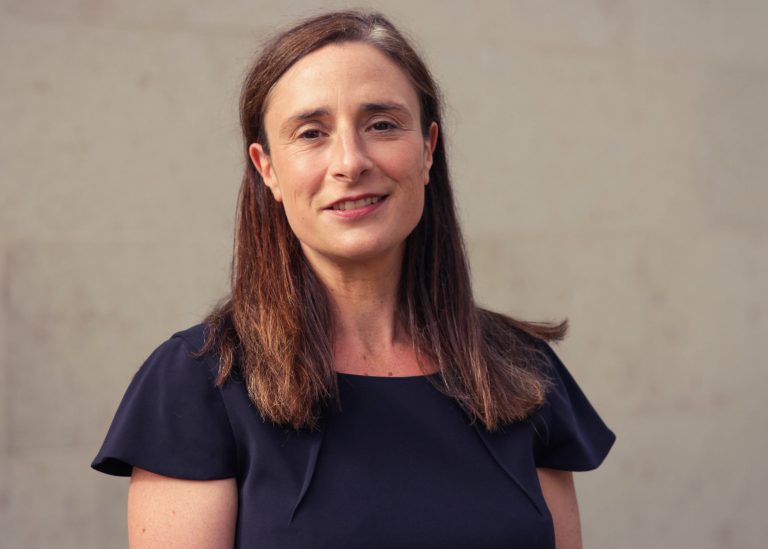 Professional woman standing outdoors, illustrating commentary on pressures facing renters and landlords