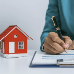 A small house next to a woman writing on a clipboard