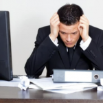 Landlord stressed over paperwork and new rental legislation at his desk