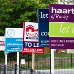 Multiple estate agent boards showing rental properties let in the UK housing market.
