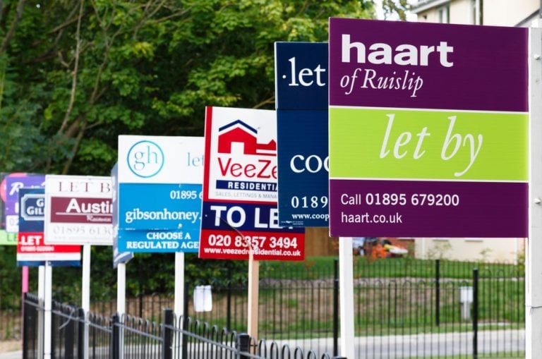 Multiple estate agent boards showing rental properties let in the UK housing market.