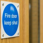 Blue fire door safety sign reminding to keep the door shut.