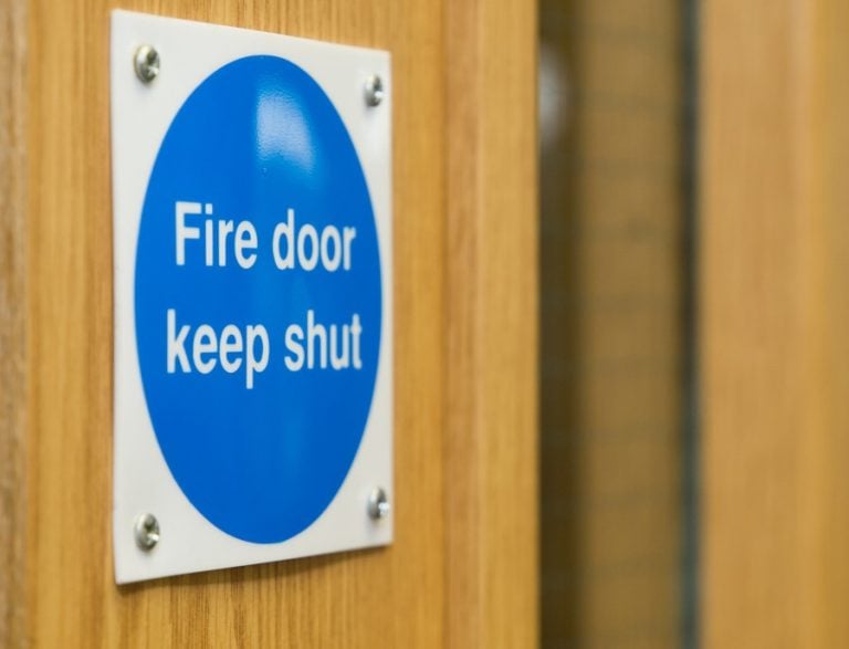 Blue fire door safety sign reminding to keep the door shut.