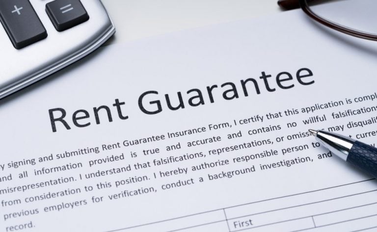 Close-up of a Rent Guarantee contract with pen and calculator.