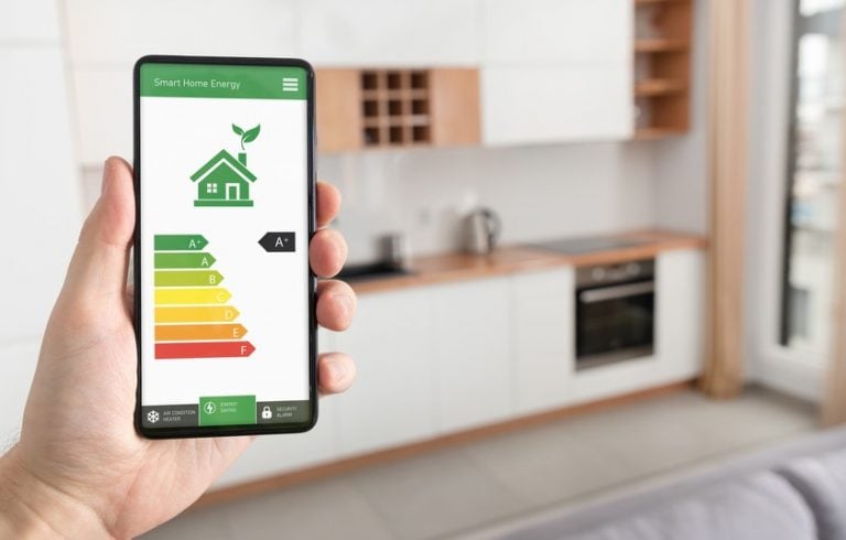 Smartphone showing smart home energy efficiency rating in a modern kitchen