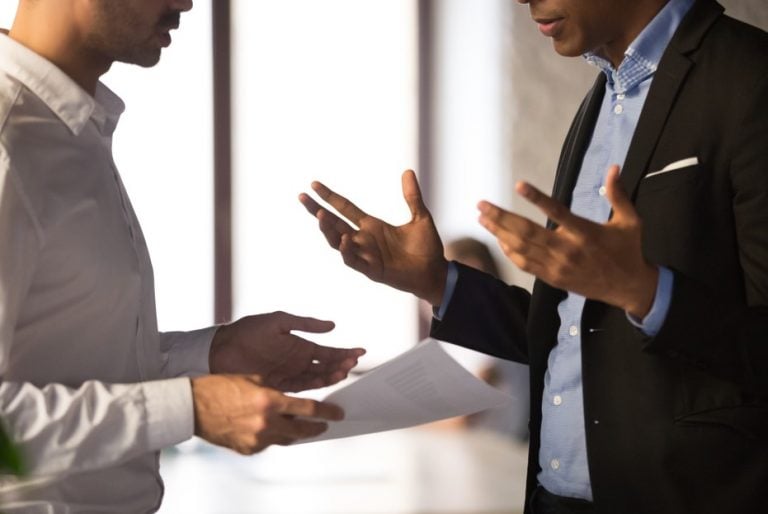 Two professionals discussing withheld landlord documents during a property handover.