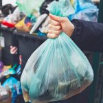 Pic of woman holding a bag of rubbish as tenants leave rented house filthy property118