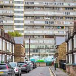 Contrast between traditional terraced houses and a large modern social housing block in an English city