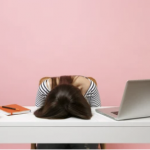 Person with head on desk at a workspace reflecting stress over PRS challenges