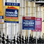 Property for sale and sold signs outside UK houses showing active housing market