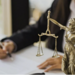 Justice scales and person writing at a desk