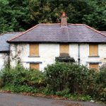 Boarded-up house representing a fixer-upper property opportunity.