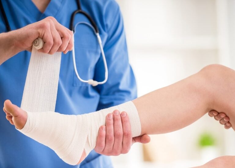 Doctor or nurse bandaging a foot property